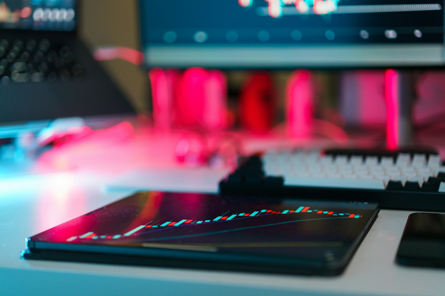 A tablet displays financial charts on a modern office desk.